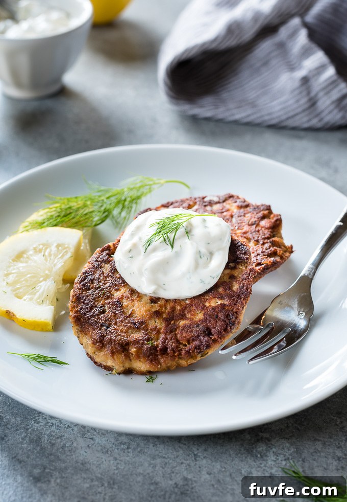 Crispy salmon cakes on a plate with lemon dill sauce