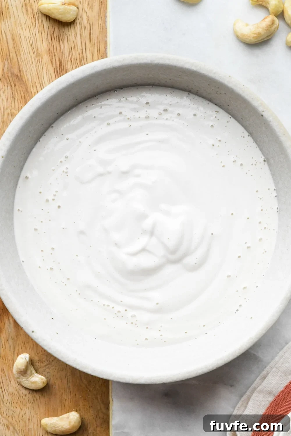 A grey ceramic bowl filled with cashew cream made with 3/4 cup water.