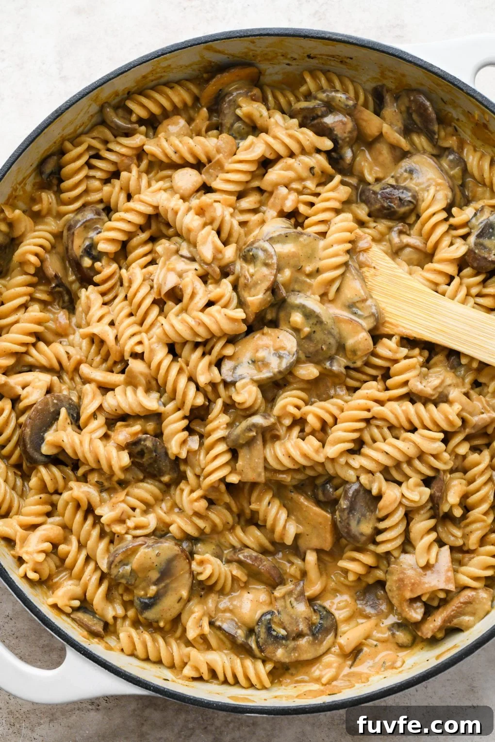 How to make creamy vegan mushroom stroganoff: Mushrooms and pasta tossed with cashew cream sauce after simmering.