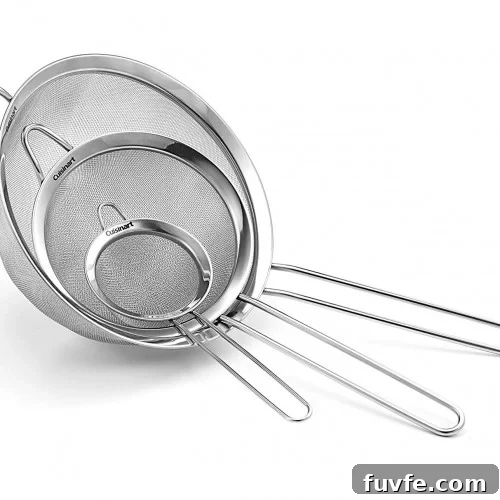 Three stainless steel mesh strainers of different sizes with long handles are nested together, each featuring a fine mesh for sifting or straining food.