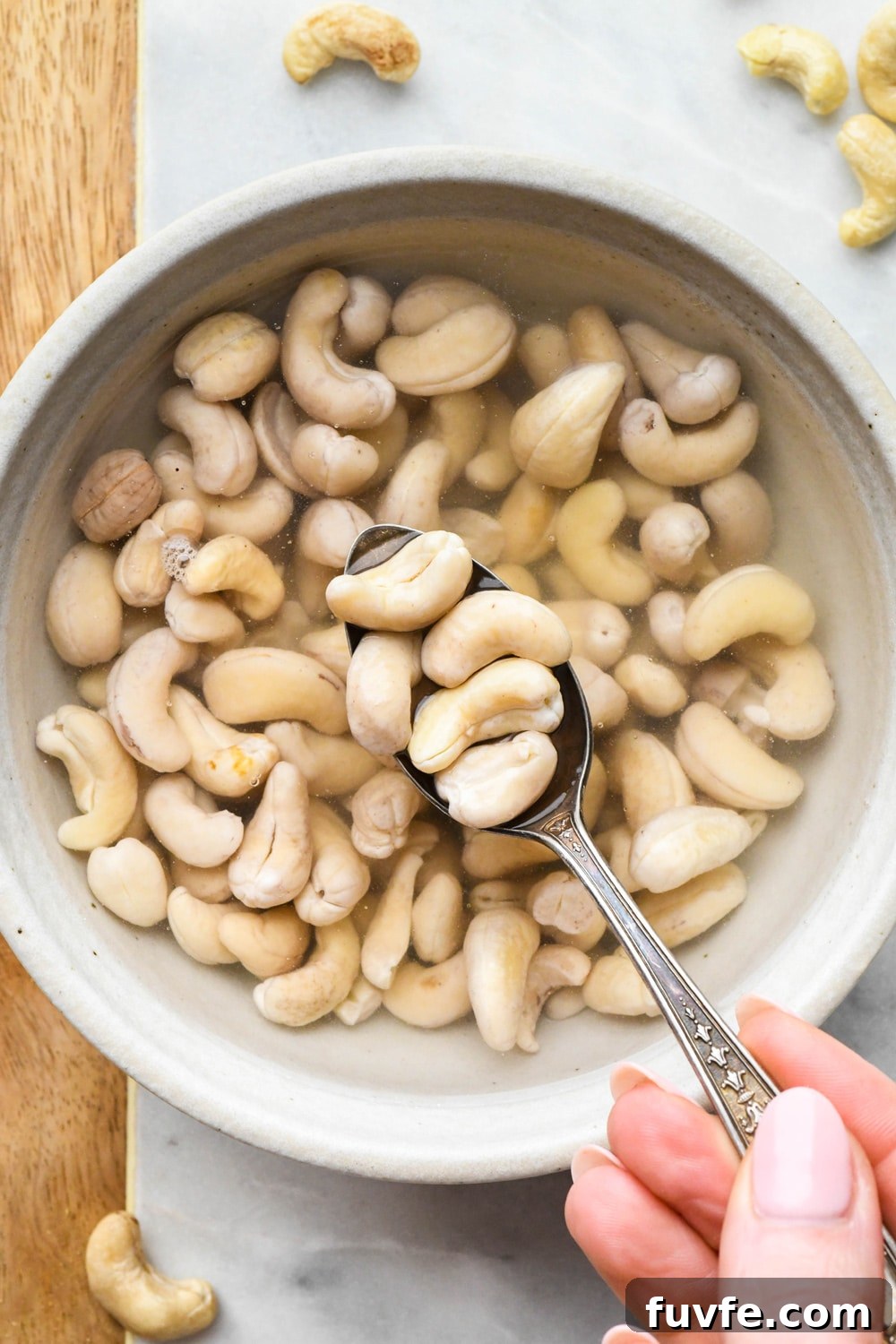 How to make cashew cream: Raw cashews in a bowl of water after soaking - cashews are pale in color and plump.