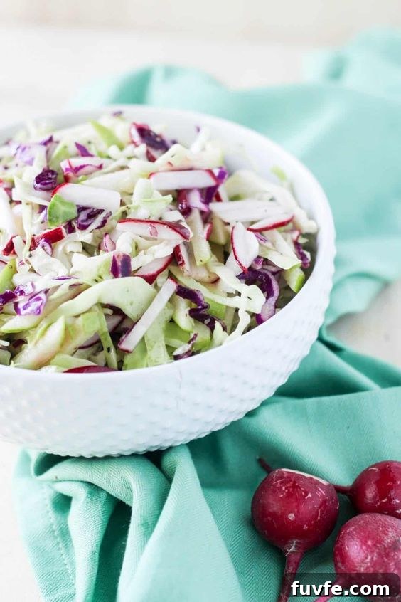 Radish Recipes: Over 20 Ideas and a Produce Guide 6 A white bowl of cabbage, radish, and apple coleslaw on a blue towel.
