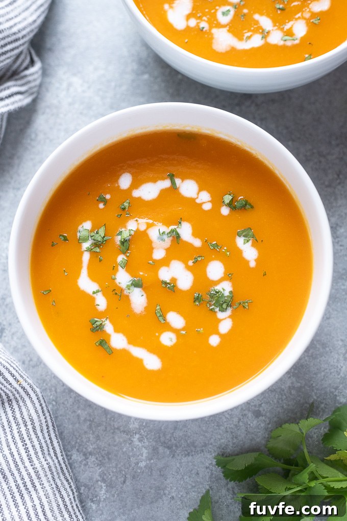 Silky Carrot and Ginger Soup Recipe 3 Carrot soup in a bowl with coconut milk and cilantro on top