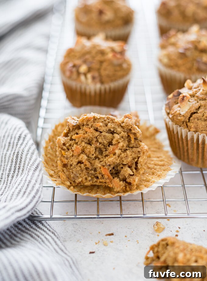 Carrot and oat muffins cut in half on a wire rack.