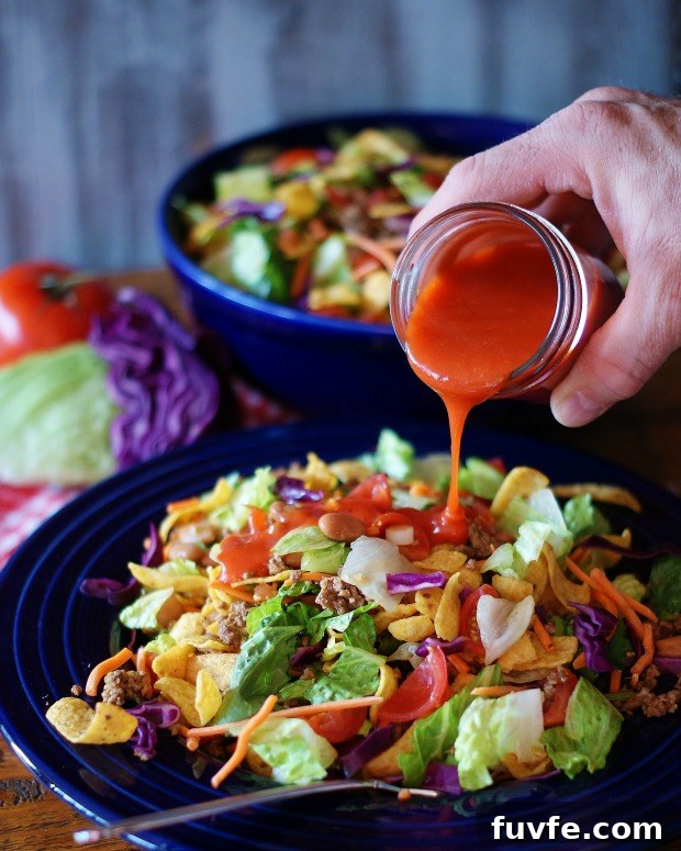 Catalina dressing being poured over a taco salad.