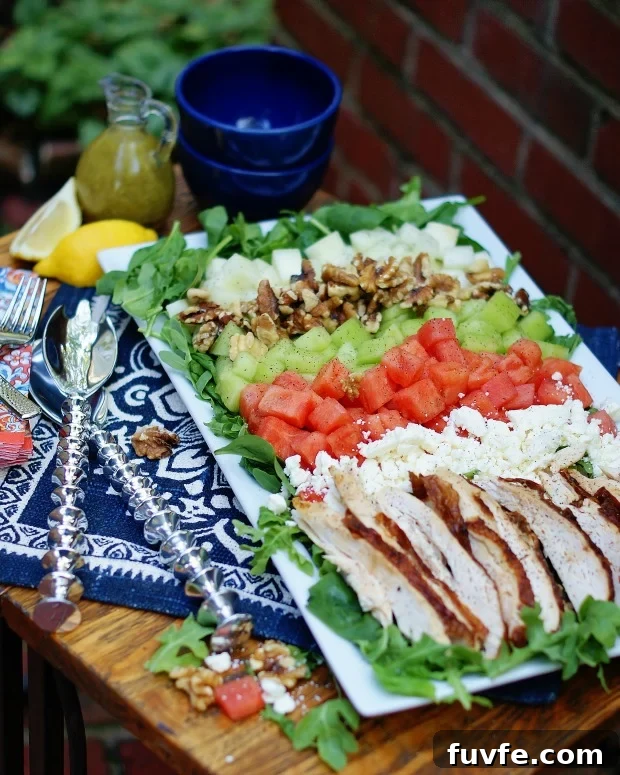 3 kinds of melons with chicken on a bed of greens.