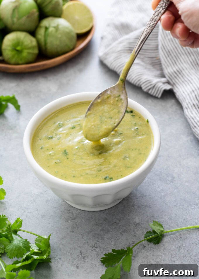 Homemade Green Enchilada Sauce with Tomatillos 2 Homemade green enchilada sauce pouring from a spoon