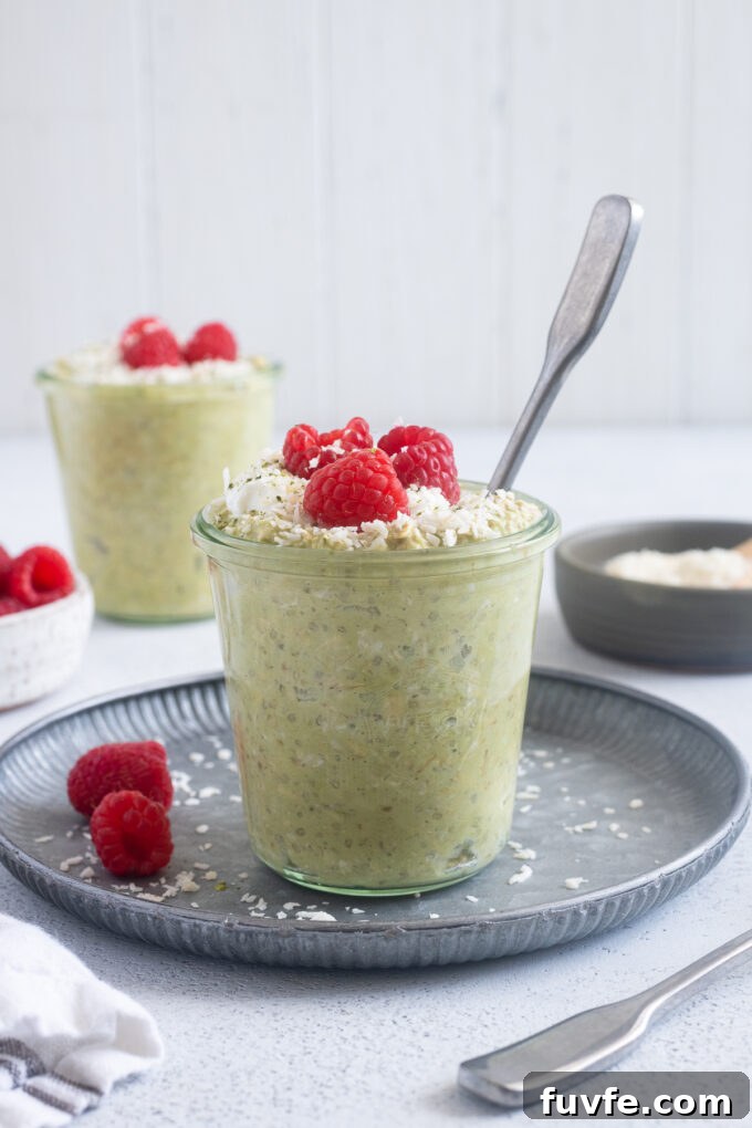 Matcha Overnight Oats Recipe: Creamy No-Cook Breakfast 3 Matcha coconut overnight oats in a jar with a spoon digging in.