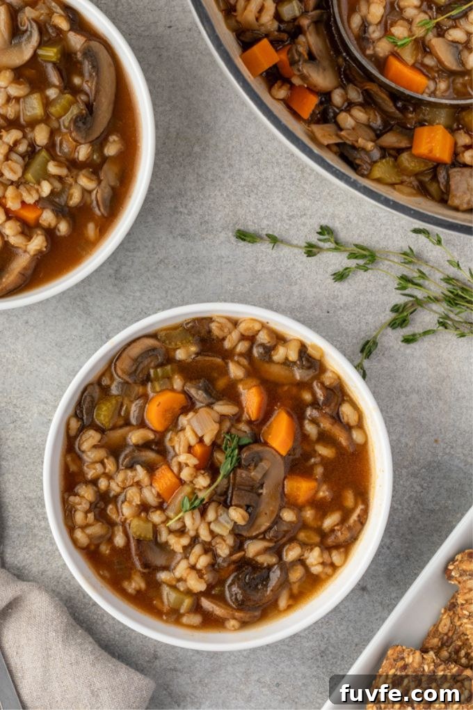 Mushroom and barley soup in a bowl with thyme