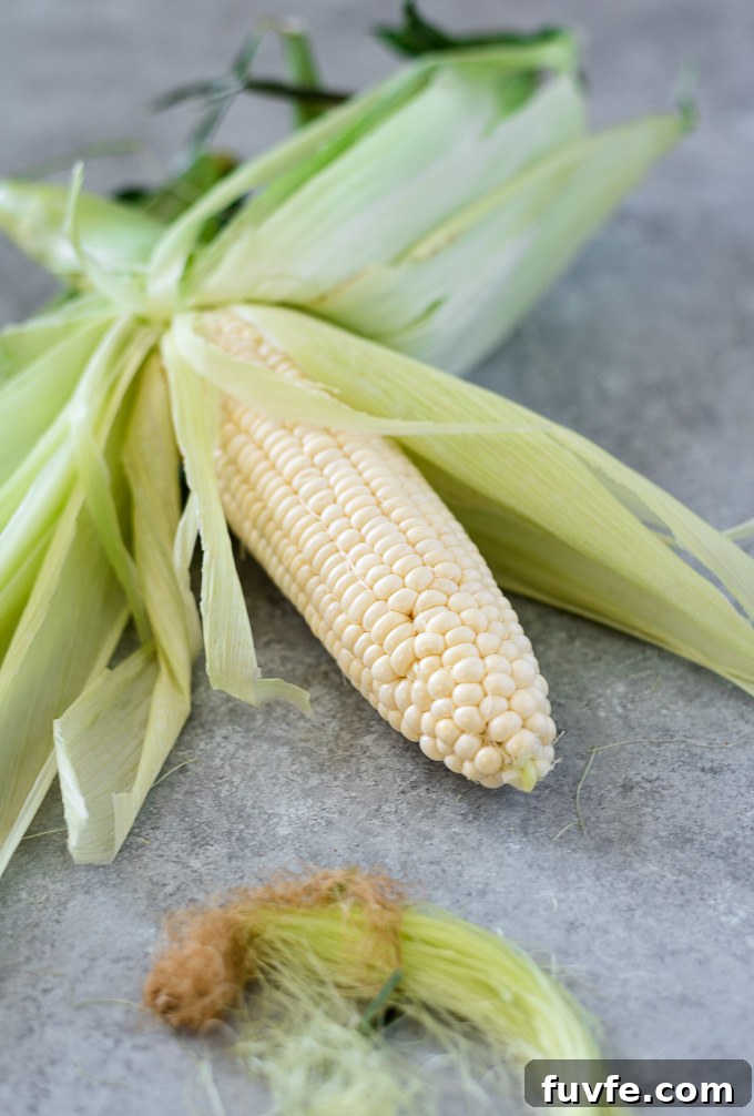 Corn on the cob with husk partially removed
