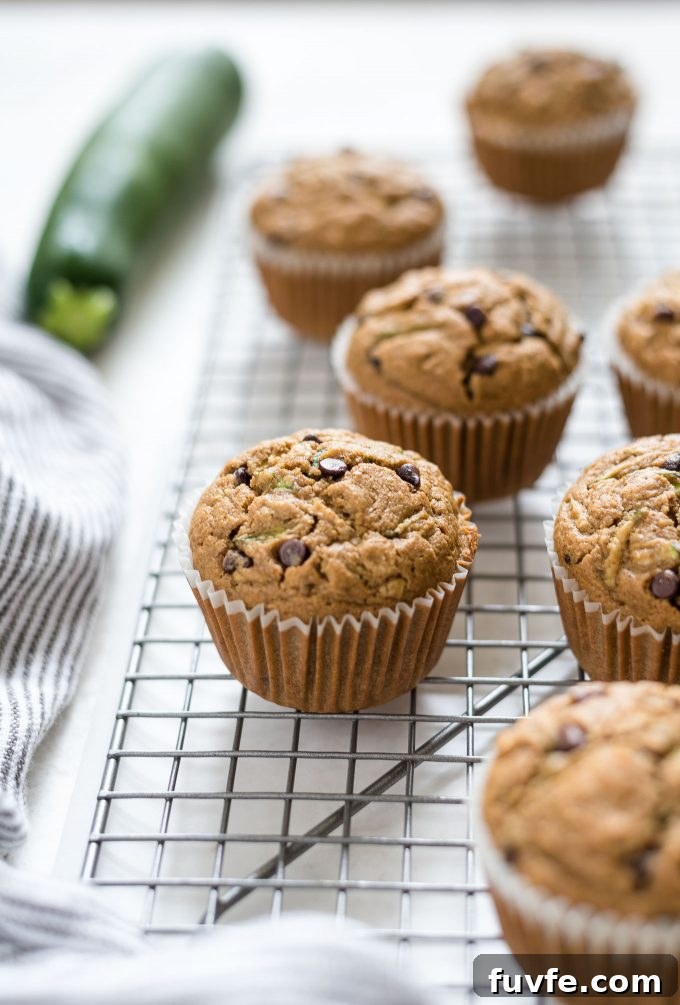 Oat Flour Zucchini Muffins Recipe - Moist and Fluffy 7 Zucchini chocolate chip muffins on a wire rack.
