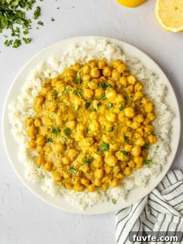Top-down view of a white plate with rice and chickpea curry.