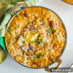 A large copper bowl with lentils and kidneys beans in a brown sauce.