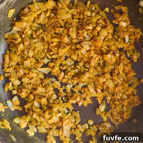 Fried onions, chilis, garlic and spices in a black pan