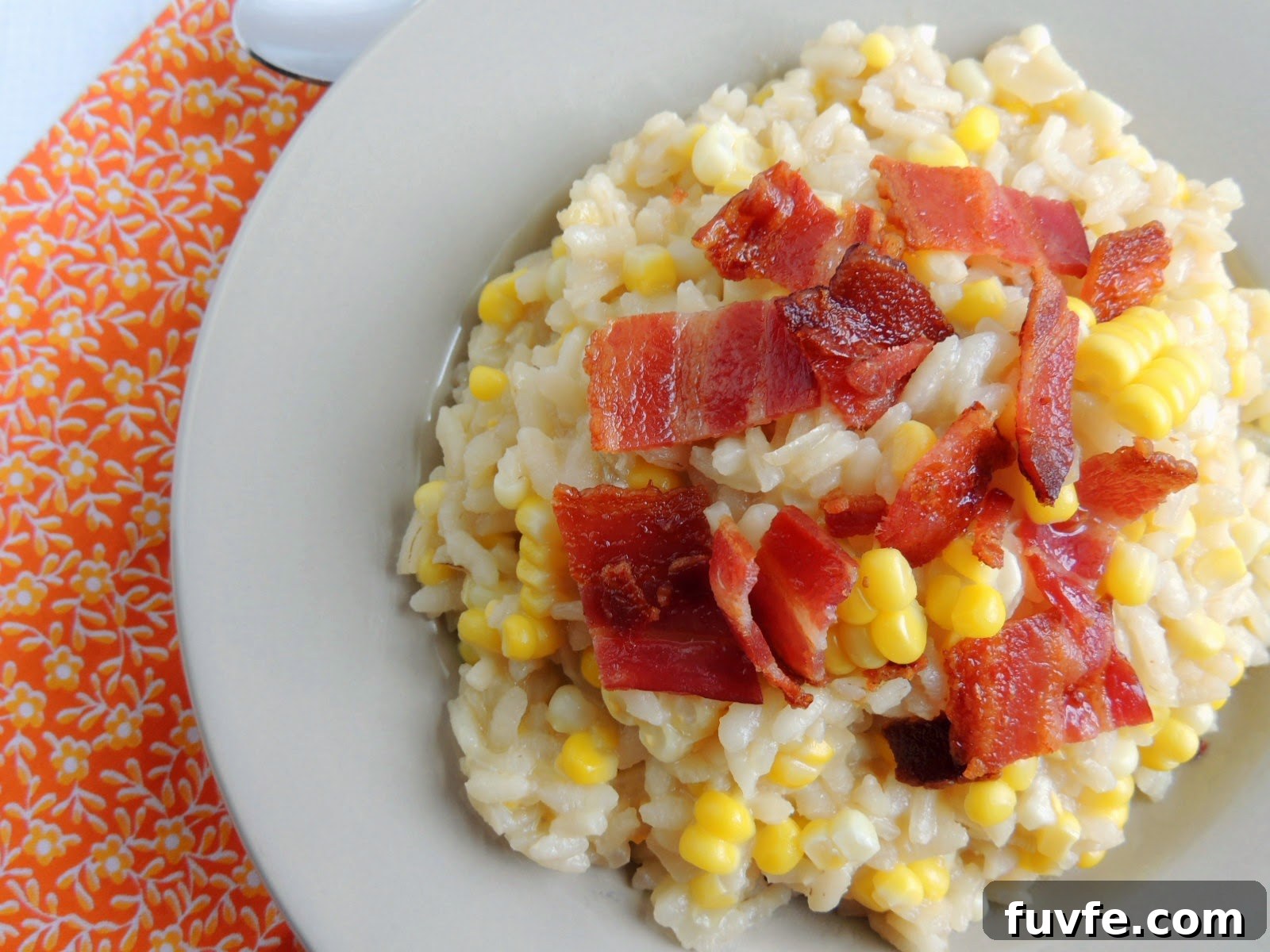 Overhead view of bacon and corn risotto in a white dish.