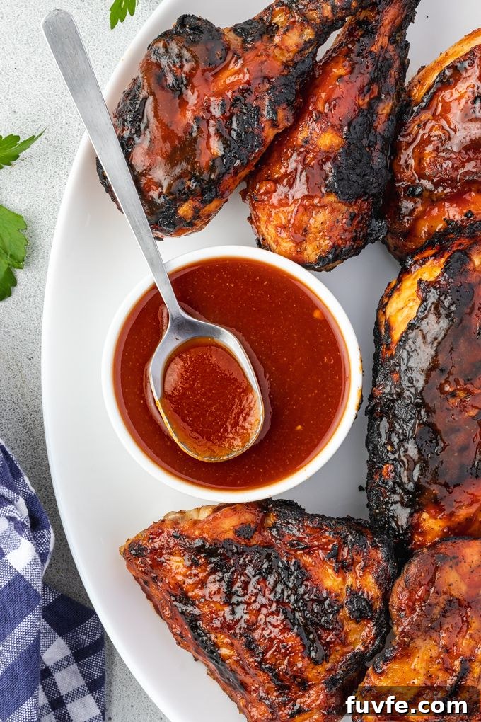 Smoky Bourbon BBQ Sauce Recipe 3 Bourbon bbq sauce in a bowl on a platter of bbq chicken