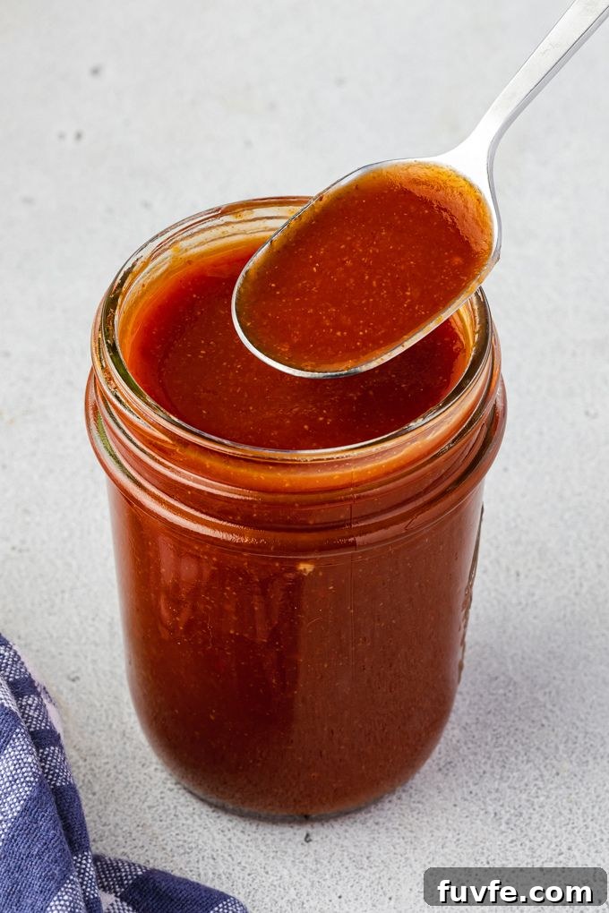 Smoky Bourbon BBQ Sauce Recipe 6 Bourbon barbecue sauce in a jar with a spoon