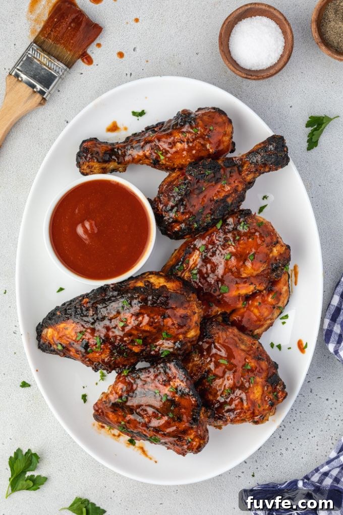 Juicy Smoky Grilled BBQ Chicken Recipe 3 Grilled barbecue chicken on a serving platter with sauce
