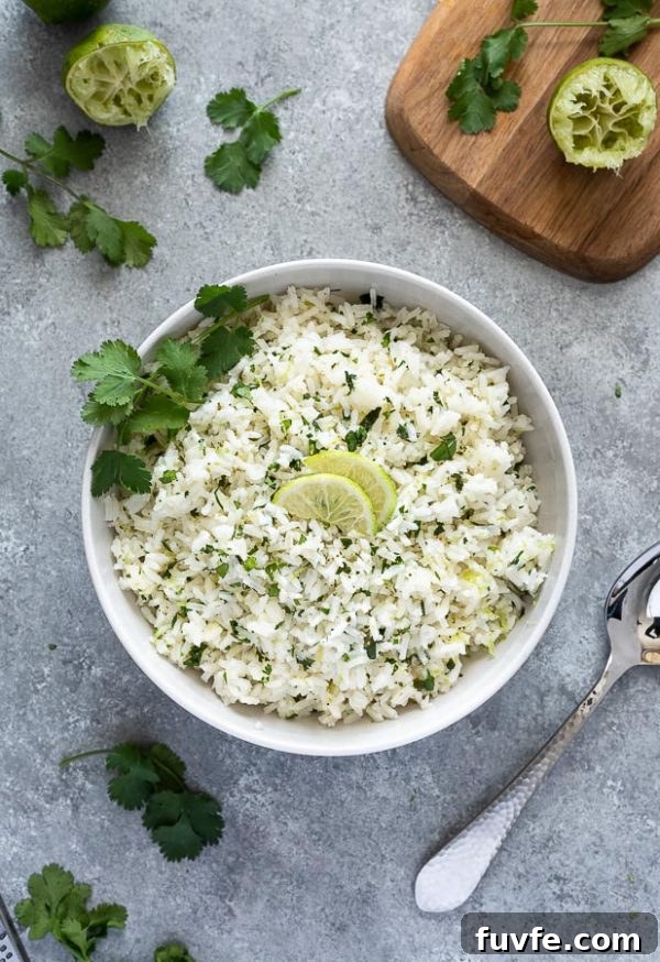 overhead shot of bowl of cilantro lime rice with limes and cilantro on top