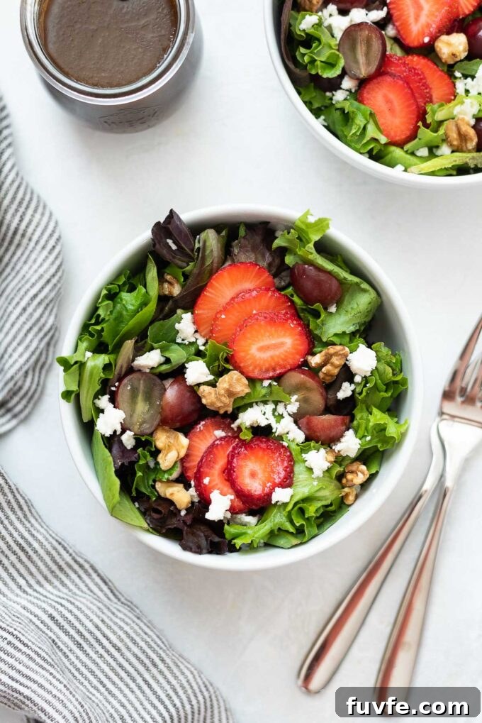 Strawberry Feta Spinach Salad with Balsamic Glaze 3 Strawberry and feta salad in a bowl with forks and dressing.
