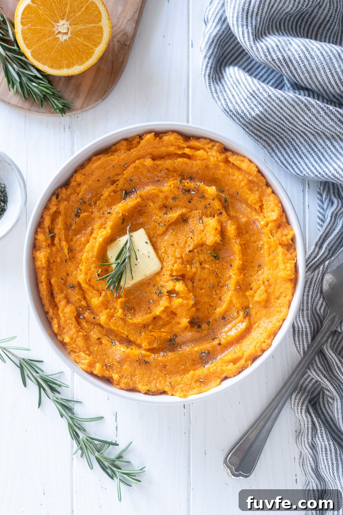 Mashed sweet potatoes with pat of butter and chopped rosemary