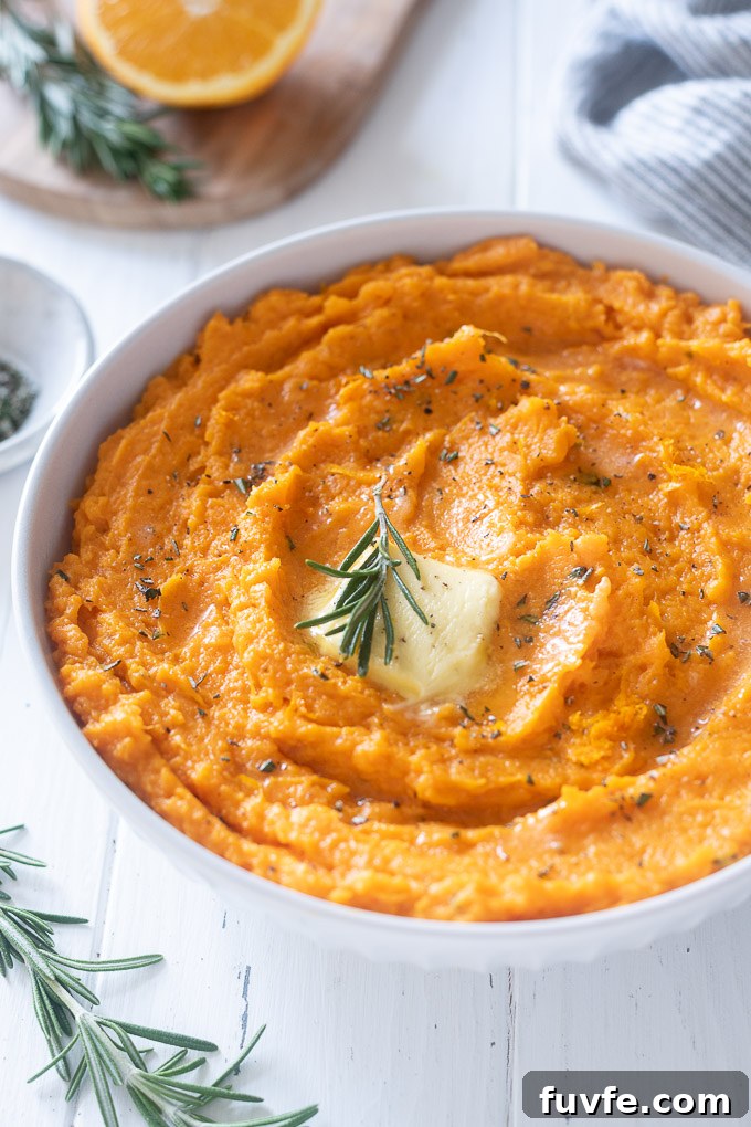 bowl of mashed sweet potatoes with butter and rosemary