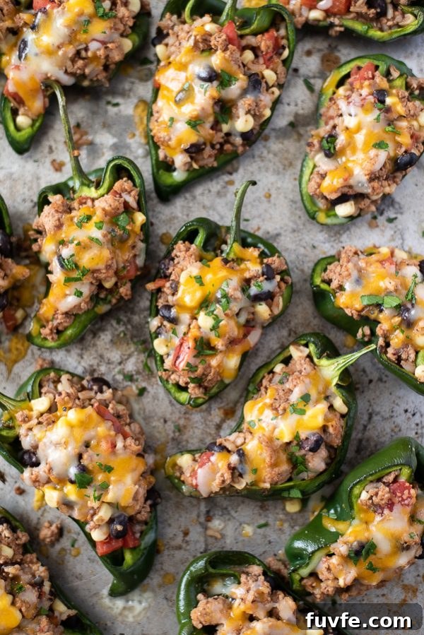 stuffed poblanos on a baking sheet with cheese