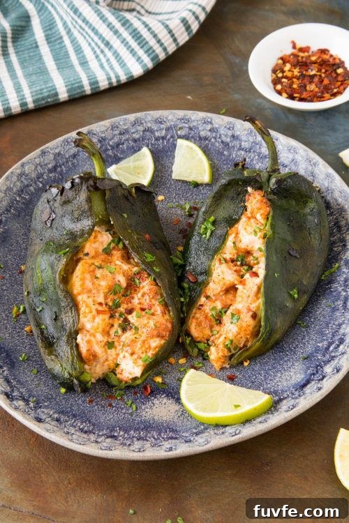 25 Poblano Pepper Recipes with Roasting and Storage Tips 18 Two cream cheese stuffed poblano peppers on a blue plate.