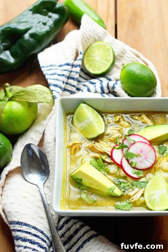 25 Poblano Pepper Recipes with Roasting and Storage Tips 19 Overhead view of a bowl of Mexican Chicken Pozole with limes.
