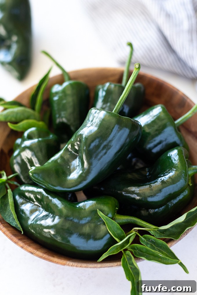Teak bowl filled with poblano peppers with linen alongside