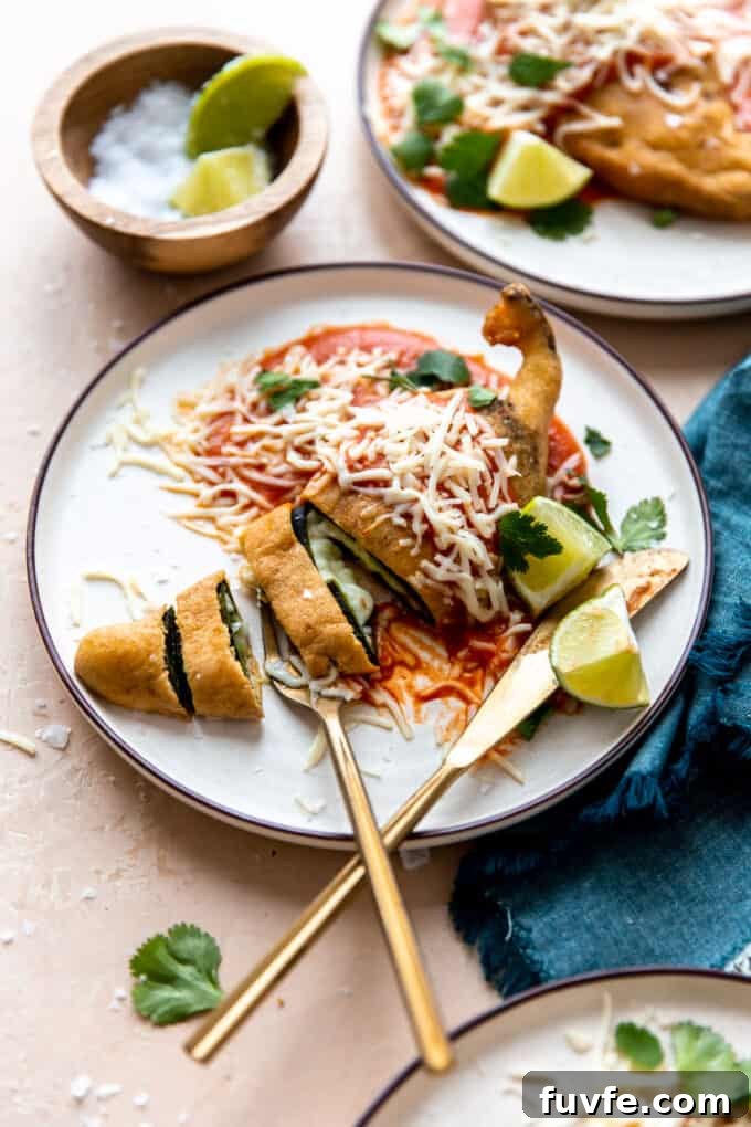 Chile rellenos on a white plate with fork and knife.
