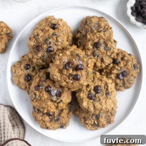 Pumpkin breakfast cookies piled on a white plate.