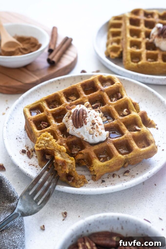 Oat flour pumpkin waffles with bite taken out.