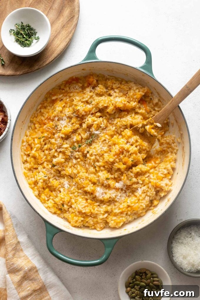 Creamy Pumpkin Risotto with Parmesan and Sage 3 Pumpkin risotto in a dutch oven with thyme sprig.
