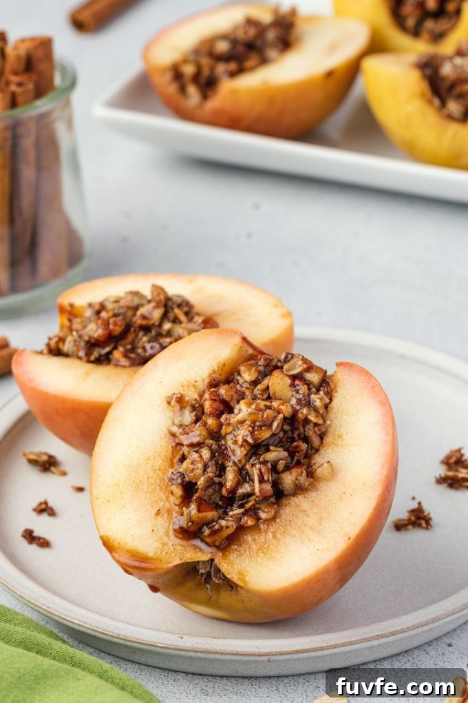Baked apple cut in half with oat pecan filling in the middle