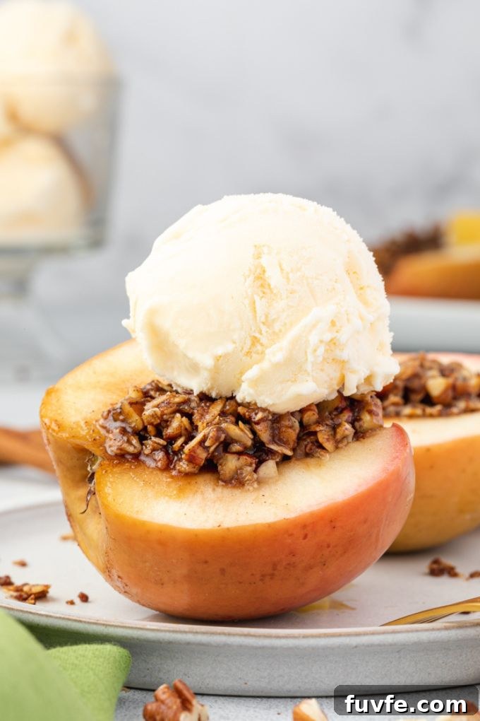 Baked apples cut in half on a plate with ice cream