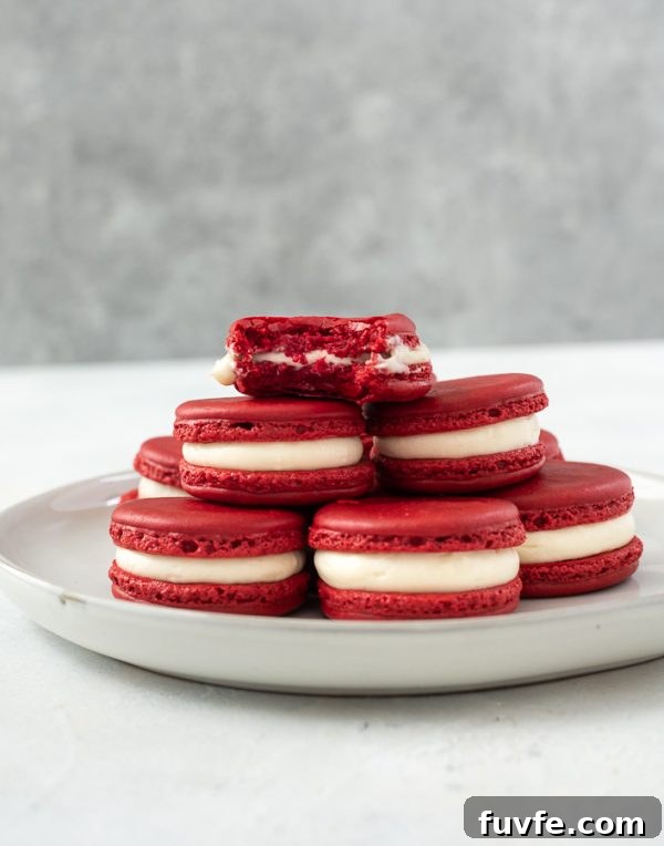 plate of red velvet macarons with a bite out of top cookie