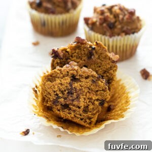 Pumpkin oat flour muffins with front muffin cut in half.