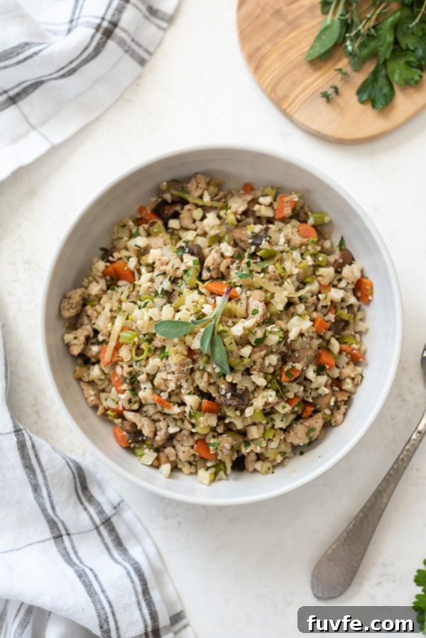 Low-Carb Cauliflower Rice Stuffing Recipe 2 overhead shot of low carb riced cauliflower stuffing in serving bowl with sage on top