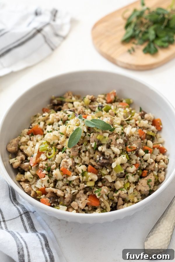 Low-Carb Cauliflower Rice Stuffing Recipe 3 low carb riced cauliflower stuffing in white serving bowl with sage on top