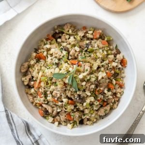 Low-Carb Cauliflower Rice Stuffing Recipe 7 overhead shot of low carb riced cauliflower stuffing in serving bowl with sage on top