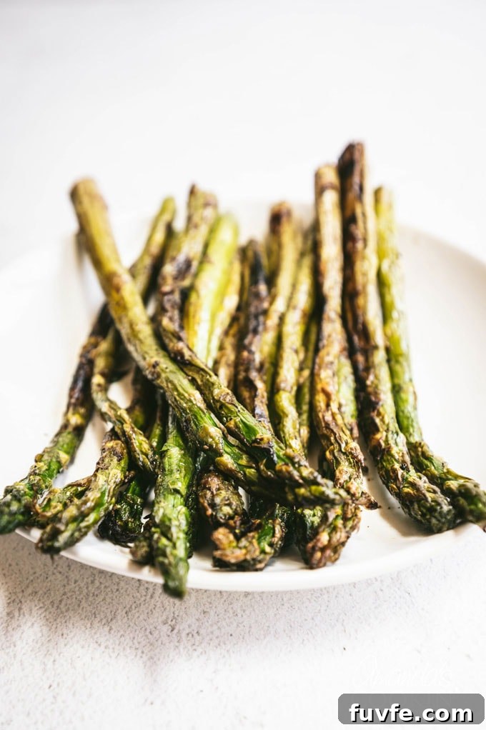 Perfect Grilled Asparagus with Lemon and Garlic 2 grilled asparagus on a white plate