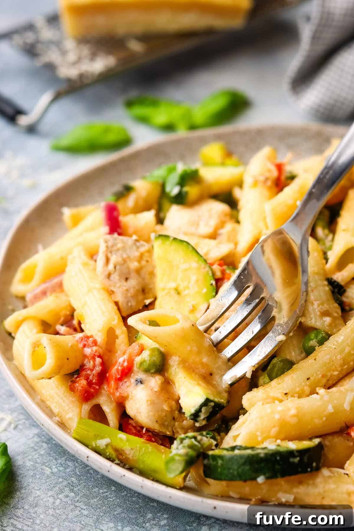 Creamy Chicken Pasta Primavera with Spring Vegetables 12 A plate of pasta primavera with a fork in it.