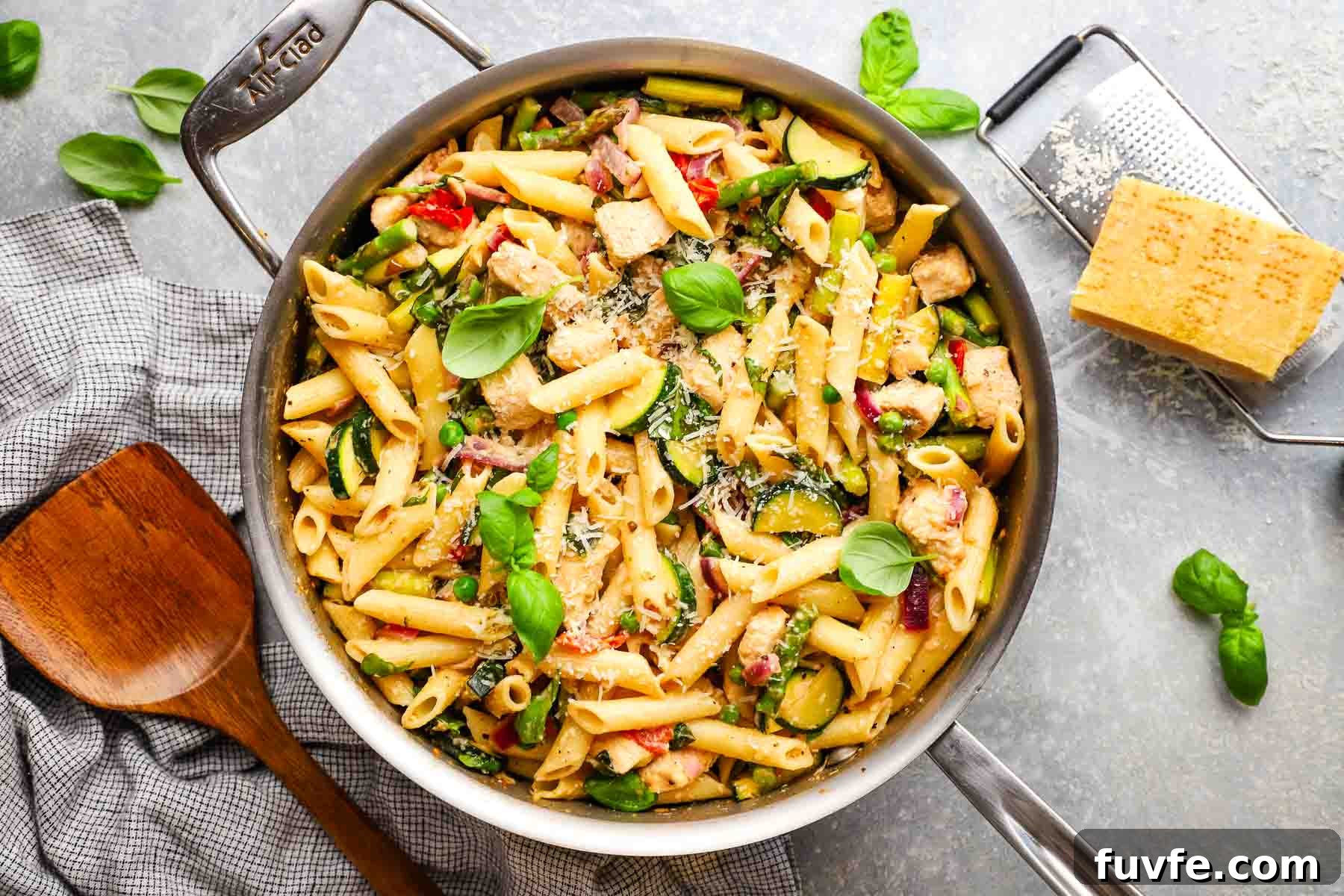 Creamy Chicken Pasta Primavera with Spring Vegetables 13 a skillet of pasta primavera topped with fresh basil.