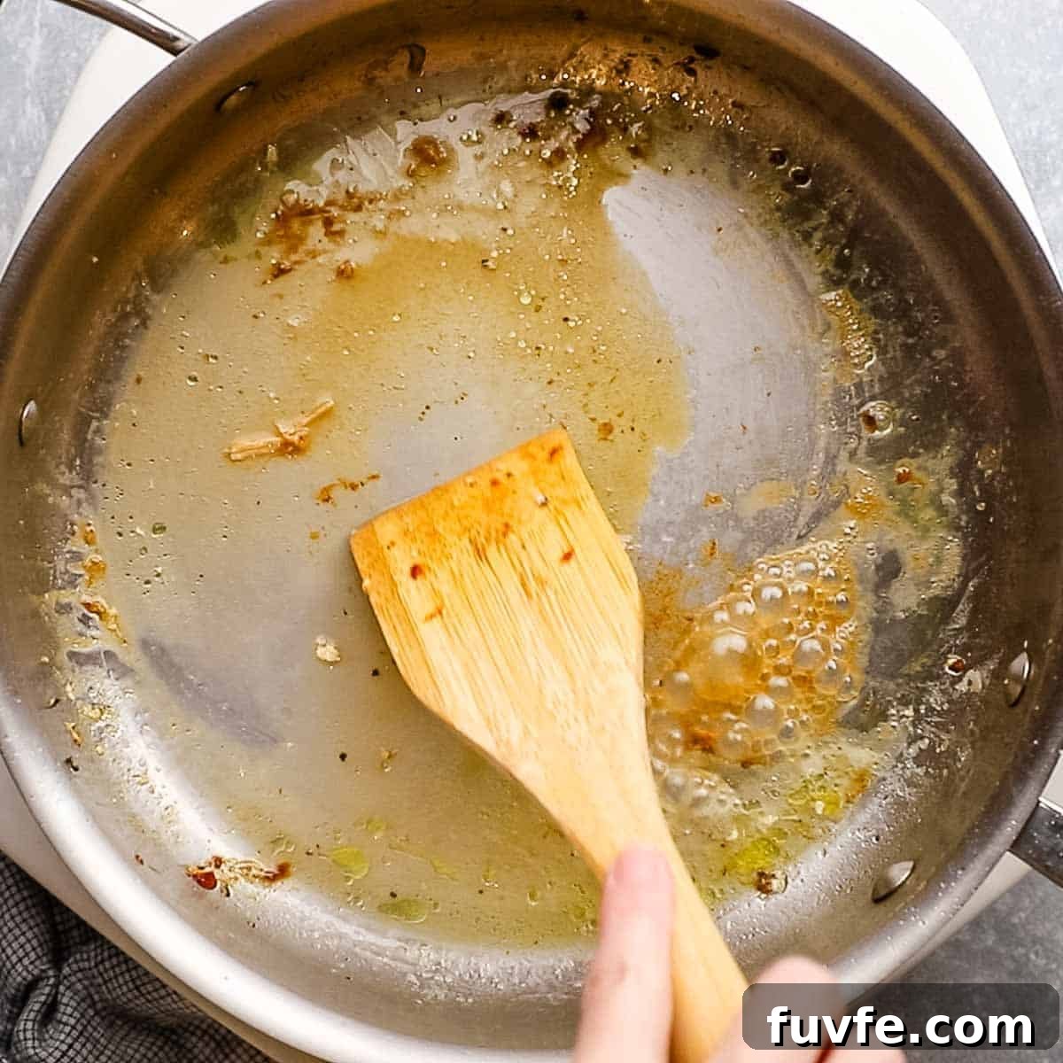 Creamy Chicken Pasta Primavera with Spring Vegetables 6 scraping off the brown bit from the skillet with a wooden spoon and some water