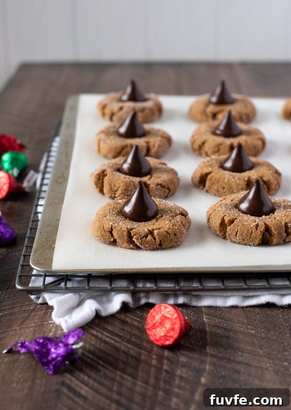 Gluten-Free Peanut Butter Blossom Cookies 4 gluten free peanut butter blossoms on a baking sheet