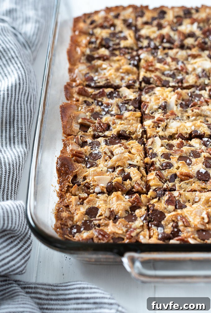 Irresistible Magic Cookie Bars Recipe - Seven Layer Bars 3 Seven layer bars in a baking dish cut into squares.