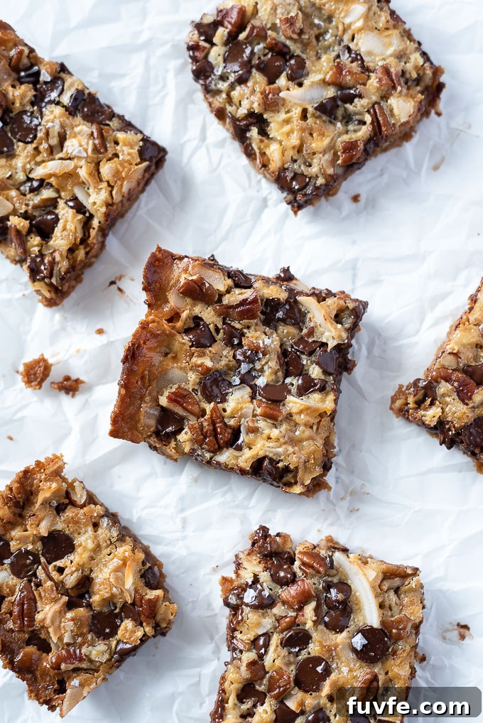Irresistible Magic Cookie Bars Recipe - Seven Layer Bars 6 Seven layer magic cookie bars on parchment paper.