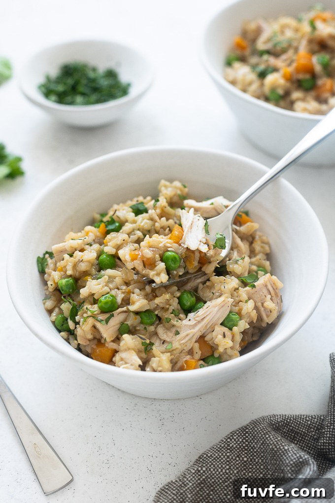 Fork digging into bowl of instant pot chicken and rice