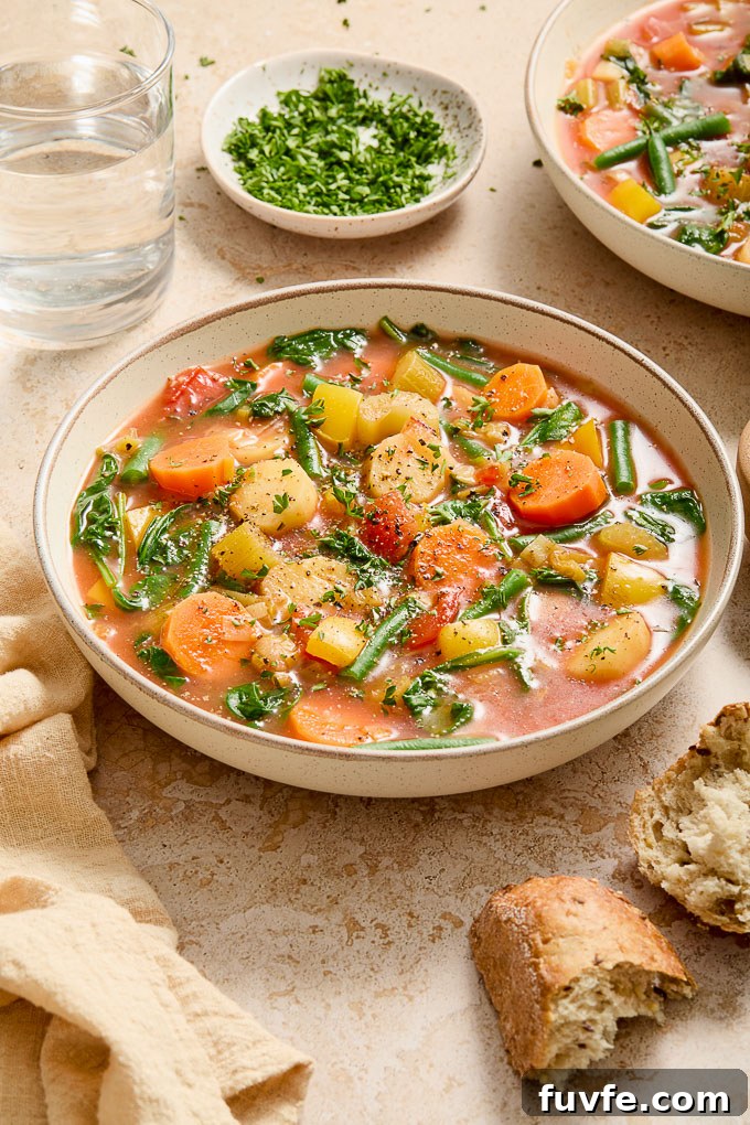 Instant pot vegetable soup in a bowl with bread and parsley garnish